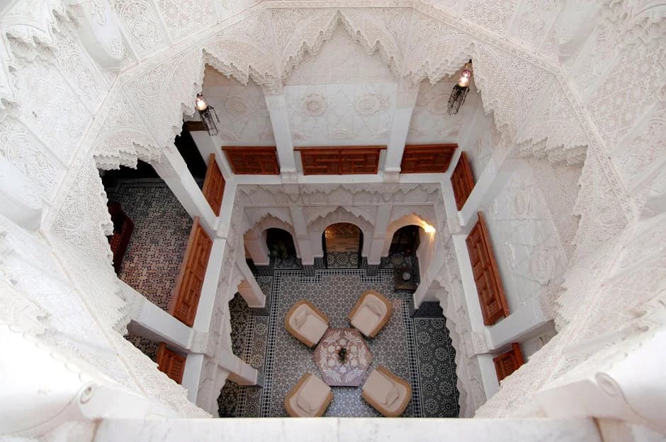 Courtyard of a sustainable riad in Marrakech with solar panels and a lush garden