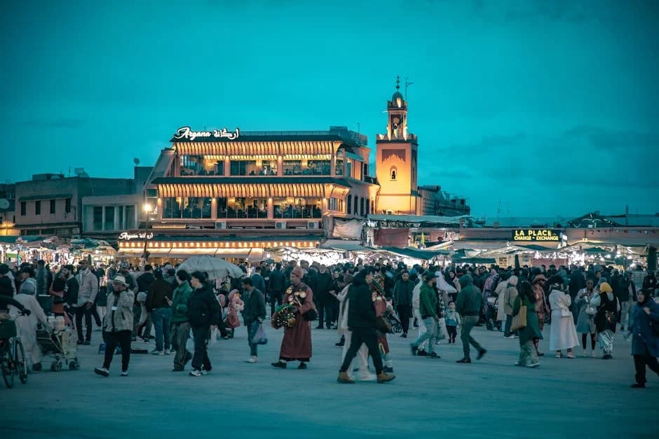 Vibrant Jemaa el-Fnaa square at sunset with Koutoubia Mosque minaret in background
